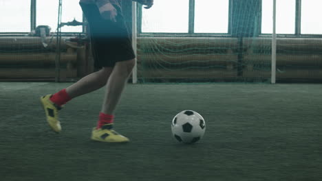 Football-Athlete-Dribbling-Ball-on-Indoor-Field